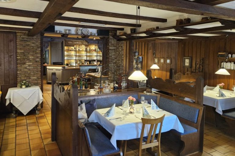 Restaurant Gemütliches Restaurant mit Holzmöbeln und eingedeckten Tischen.